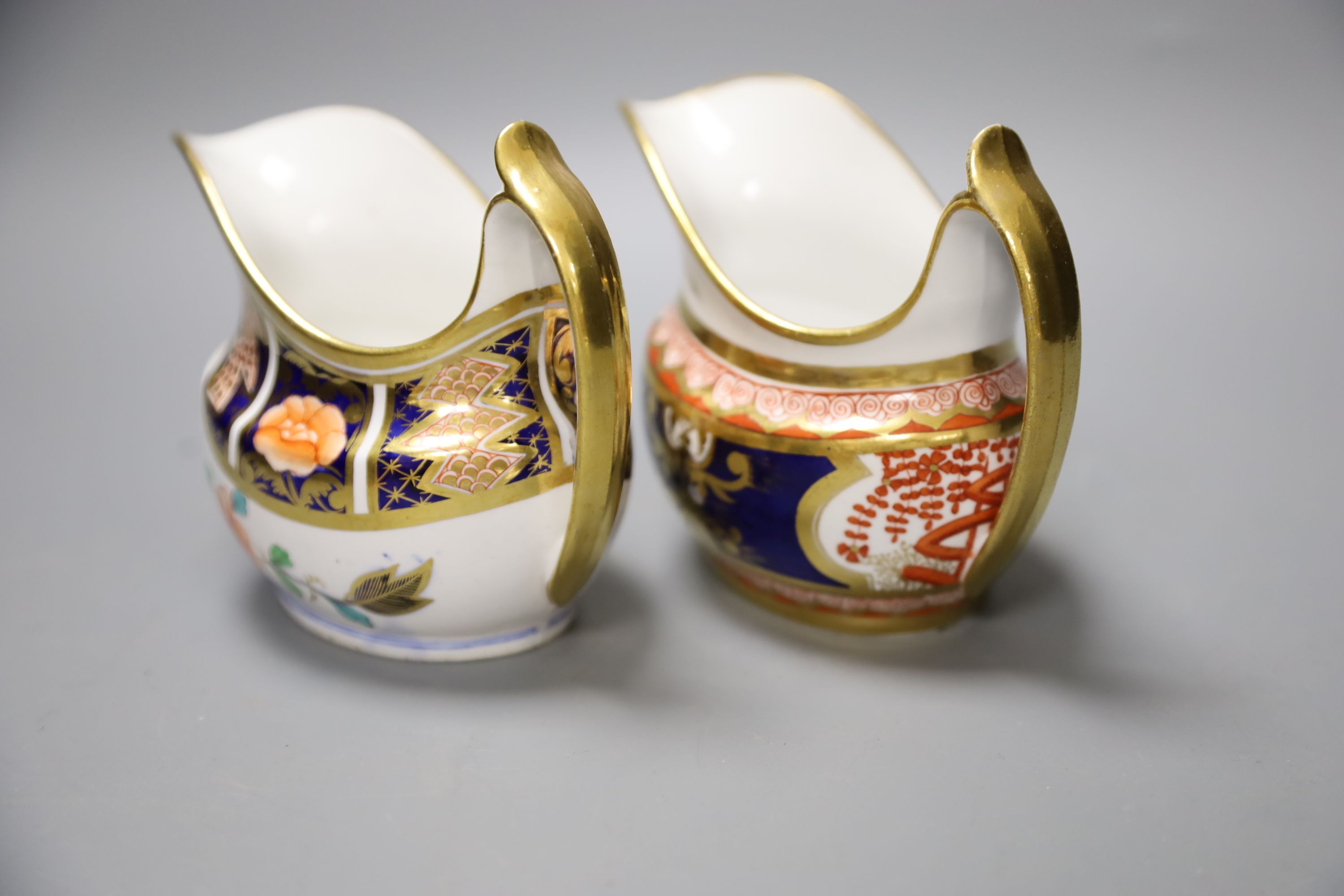 A Spode cream jug painted in imari style with the dollar pattern 715 and another Spode cream jug painted in imari style